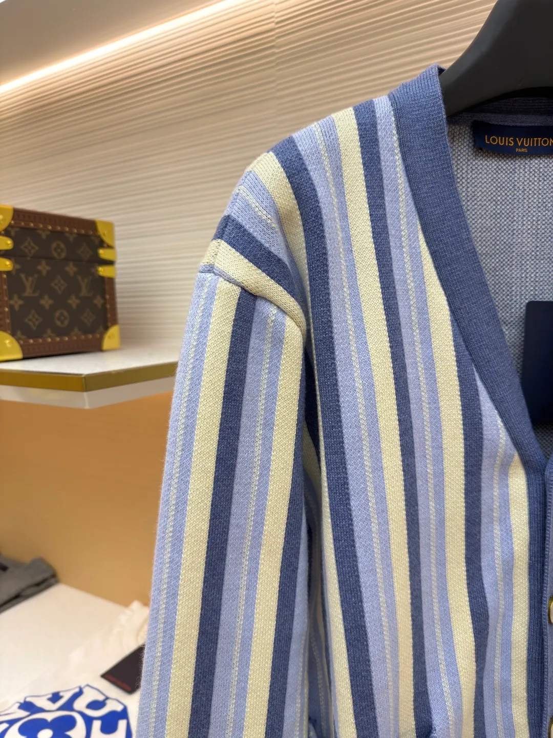 LOUIS VUITTON striped jacquard single-breasted sweater ●Original version: Purchased and developed for 15100 ●Item number: 1682314-C00 ●Fabric: wool fabric ●Technology: jacquard knitting ●Color: blue ●Version: fitted version ●Weight: about 930 grams ●Size: S-M-L-XL ●Description: This LV striped knitted cardigan is made of high-count worsted wool blended yarn. The double-ply threading process enhances the yarn's toughness. It is not easy to pill and has an outstanding drape feeling. The body of the garment adopts vertical jacquard weaving technology, with navy blue, light blue and off-white yarns interlaced with each other. The stripe width and spacing are precisely controlled by a computerized flat knitting machine, so that the color transition is natural and even. The LV letter jacquard on the left body has been debugged several times through plate making to ensure that the pattern is three-dimensional and clear. The V-neck, cuffs, and hem all use ribbing technology and are pre-shrunk to shape, making them less likely to loosen and deform after long-term wear. The buttons are made of custom-made metal, with matte sandblasting on the surface, and are hand-stitched with the seams of the body. The pockets use welting technology, and the edges are flat without jumpers. Every detail reflects the exquisite clothing craftsmanship and brand ingenuity. The overall wiring is straight and delicate, the fabric is comfortable and soft, and the color is consistent without color difference. It can be matched with the same style to create a fashionable look and control various occasions. Customized accessories, complete with three standards, same style for men and women!